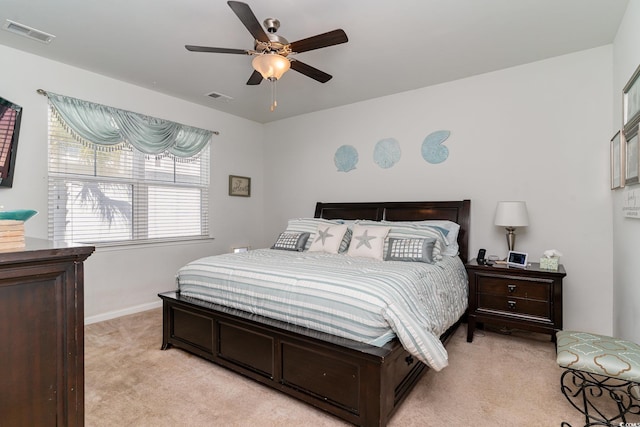 bedroom featuring visible vents, baseboards, light colored carpet, and a ceiling fan