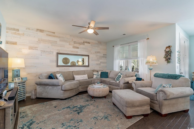 living room featuring ceiling fan and dark wood-type flooring