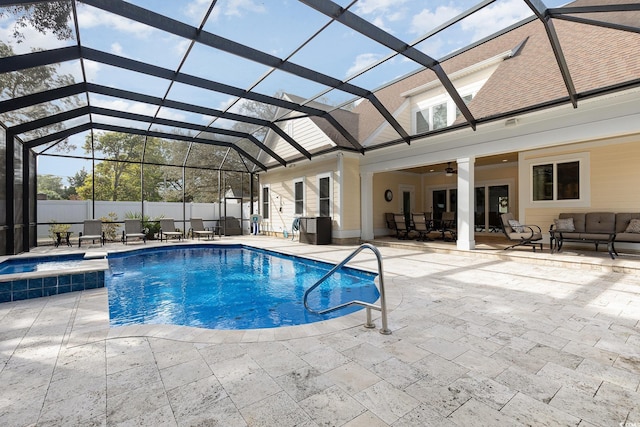 view of pool featuring glass enclosure, ceiling fan, and a patio