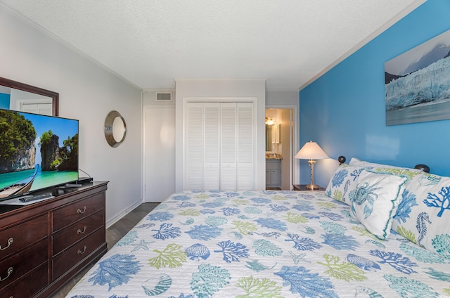 bedroom with ensuite bath, hardwood / wood-style floors, a textured ceiling, ornamental molding, and a closet