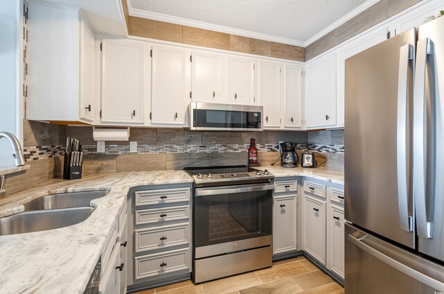 kitchen featuring light stone countertops, appliances with stainless steel finishes, sink, and white cabinets