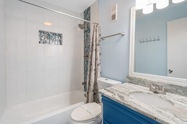 full bathroom with shower / tub combo with curtain, vanity, and toilet