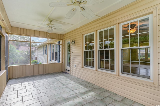 unfurnished sunroom with ceiling fan