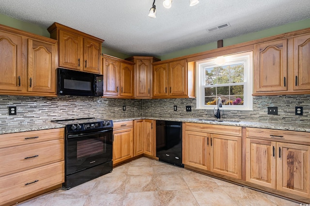 kitchen featuring black appliances, light stone counters, backsplash, a textured ceiling, and sink