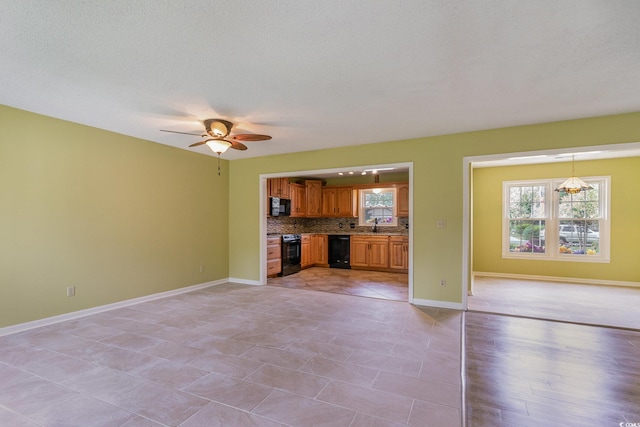 unfurnished living room featuring light tile patterned flooring, ceiling fan, a textured ceiling, and sink