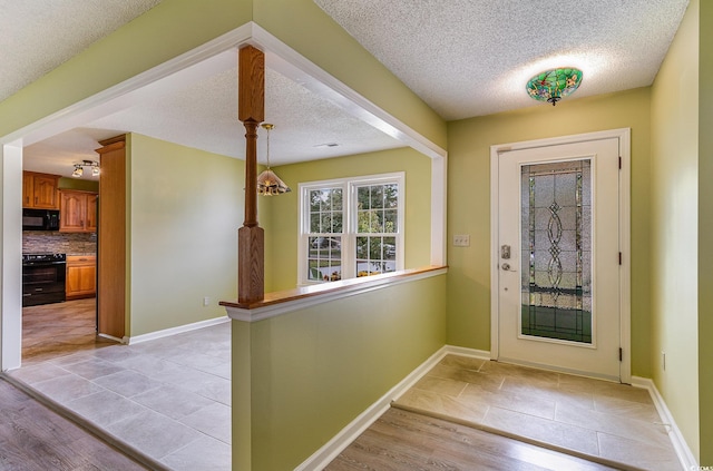 foyer with a textured ceiling and light hardwood / wood-style floors