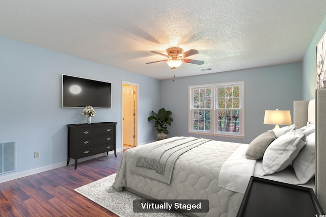 bedroom featuring dark hardwood / wood-style flooring, a textured ceiling, and ceiling fan