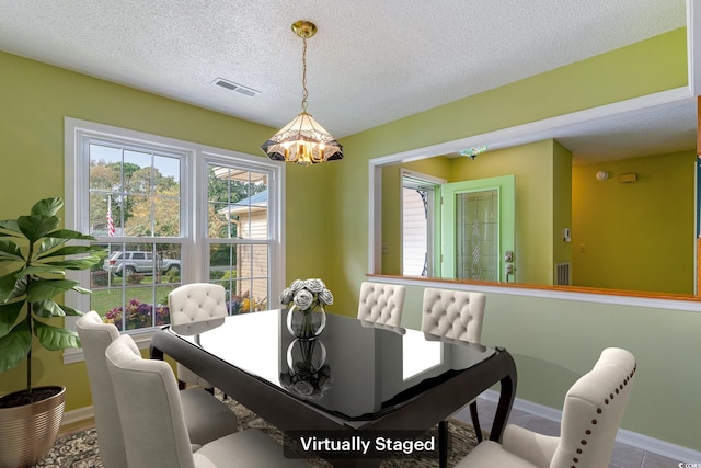 dining space featuring a textured ceiling and an inviting chandelier