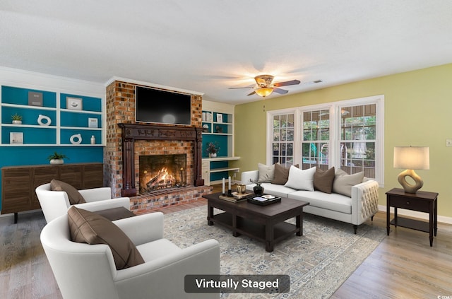 living room with a fireplace, wood-type flooring, a textured ceiling, and ornamental molding