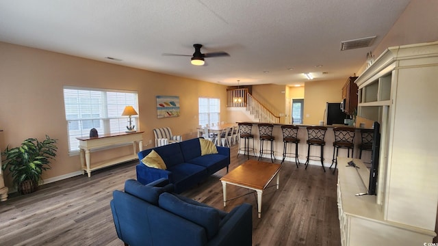 living room with ceiling fan, hardwood / wood-style floors, and a textured ceiling