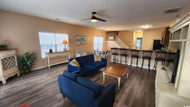 living room with dark wood-type flooring and ceiling fan