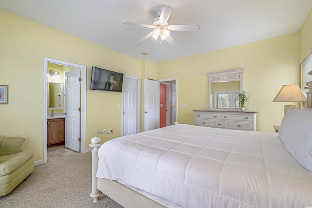 carpeted bedroom featuring sink, ensuite bath, and ceiling fan