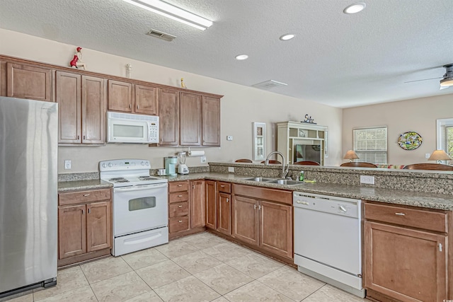 kitchen featuring light tile patterned flooring, sink, white appliances, ceiling fan, and a textured ceiling