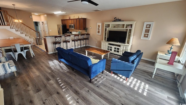 living room with dark hardwood / wood-style flooring and ceiling fan