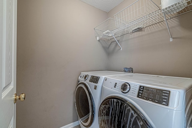 laundry room featuring washing machine and dryer and a textured ceiling