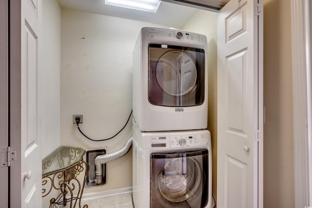 washroom featuring stacked washer / dryer and a textured ceiling