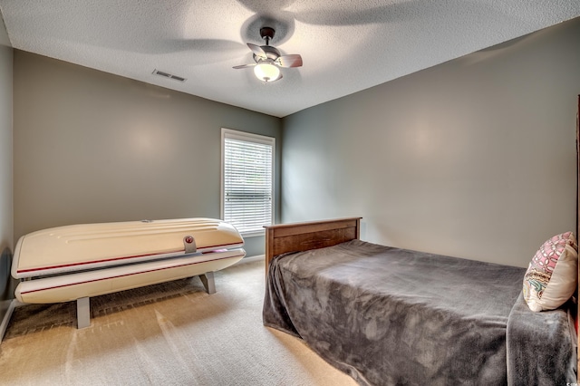 bedroom featuring a textured ceiling, carpet flooring, and ceiling fan