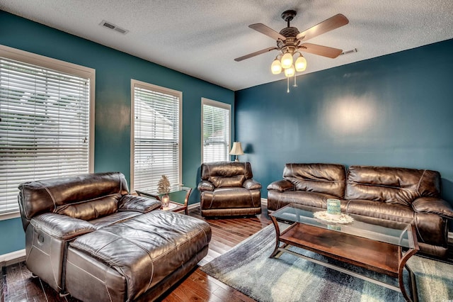 living room with hardwood / wood-style floors, a textured ceiling, and ceiling fan