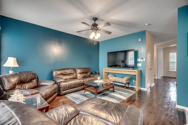 living room with dark wood-type flooring, a textured ceiling, and ceiling fan