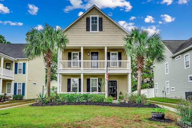 view of front facade with a front lawn and a balcony