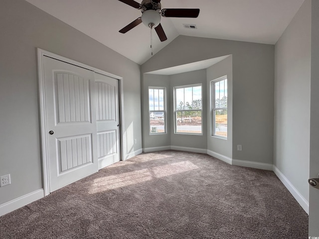 unfurnished bedroom with lofted ceiling, carpet floors, a closet, and ceiling fan