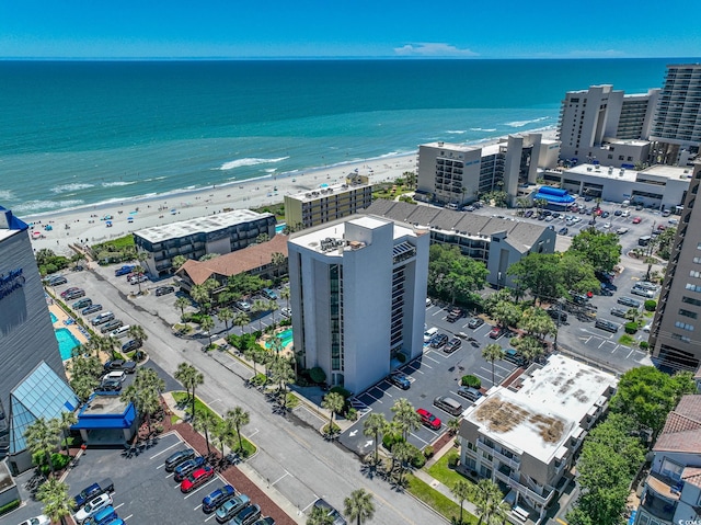 birds eye view of property with a water view and a beach view