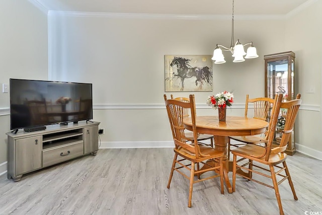 dining space featuring light hardwood / wood-style flooring, crown molding, and an inviting chandelier