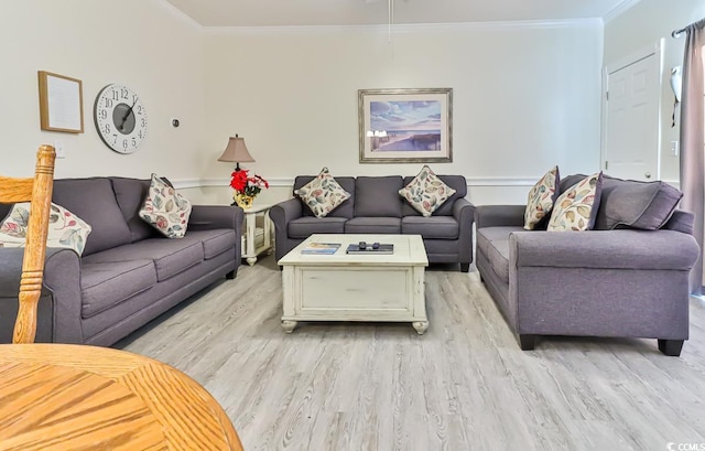 living room with light hardwood / wood-style flooring and crown molding