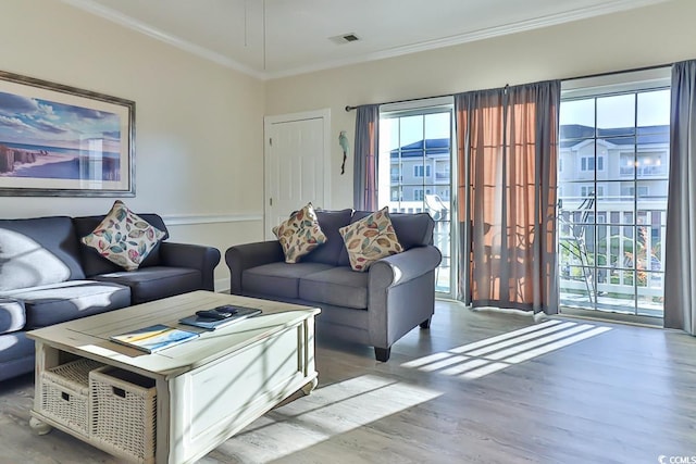 living room with light hardwood / wood-style flooring and crown molding