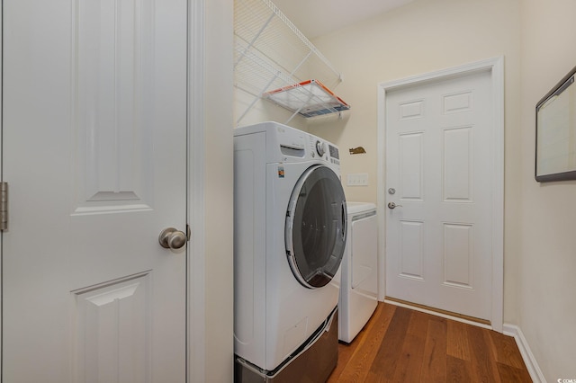 washroom with washer and clothes dryer and dark wood-type flooring