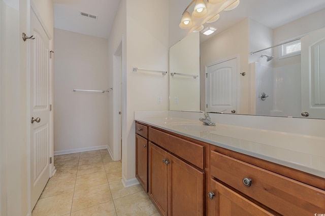 bathroom featuring tile patterned floors, a shower, and vanity