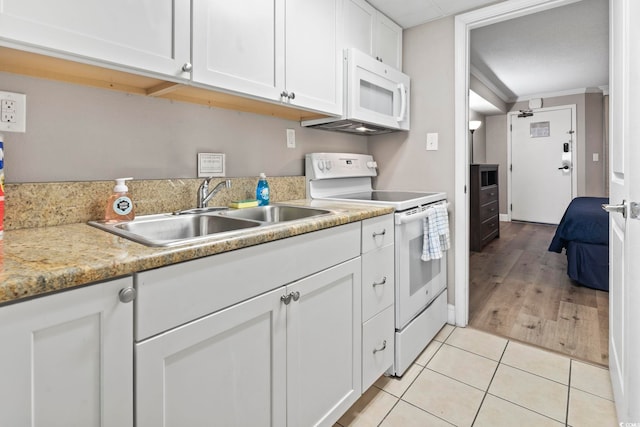 kitchen with light tile patterned flooring, sink, white cabinets, ornamental molding, and white appliances