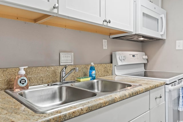 kitchen featuring white cabinetry, sink, and white appliances