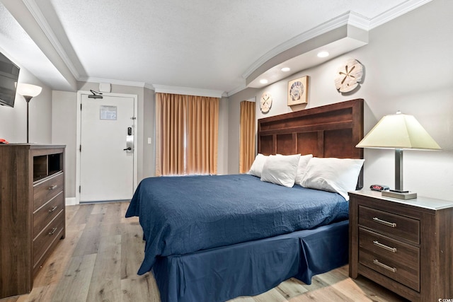 bedroom featuring crown molding, a textured ceiling, and light hardwood / wood-style floors