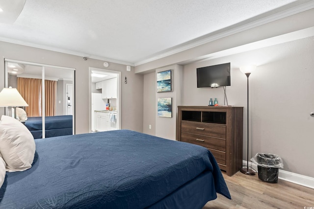 bedroom with crown molding, a textured ceiling, and light hardwood / wood-style flooring