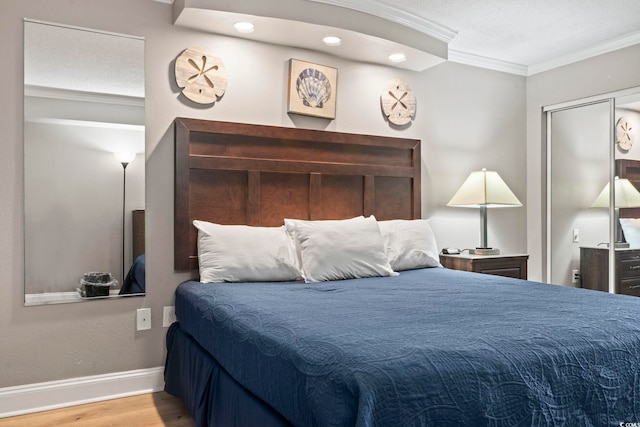 bedroom with ornamental molding and hardwood / wood-style floors