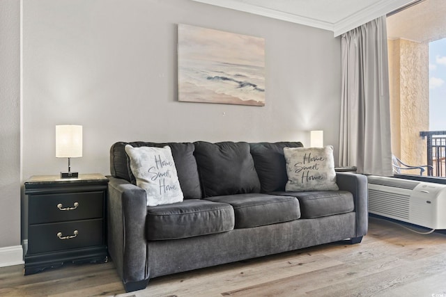 living room featuring a wall mounted air conditioner, ornamental molding, and light hardwood / wood-style floors