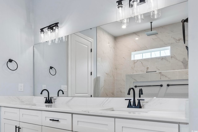 full bathroom with a sink, double vanity, and a tile shower