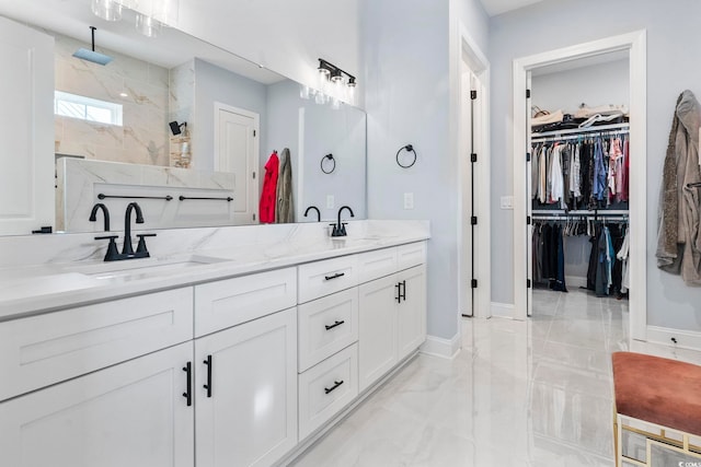 full bath featuring a sink, marble finish floor, double vanity, and a walk in shower