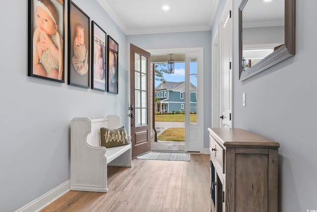 doorway featuring light wood-type flooring, baseboards, and ornamental molding