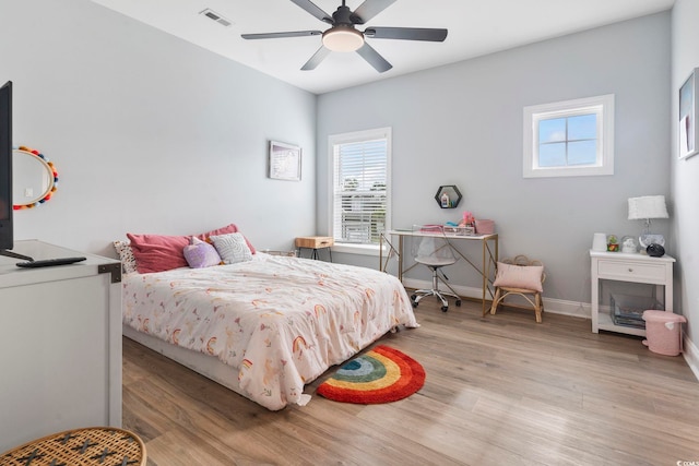 bedroom with a ceiling fan, baseboards, visible vents, and light wood-type flooring