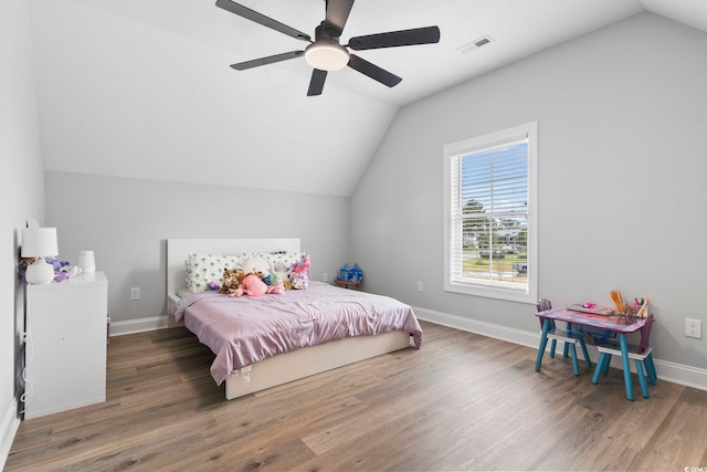 bedroom featuring wood finished floors, visible vents, baseboards, ceiling fan, and vaulted ceiling