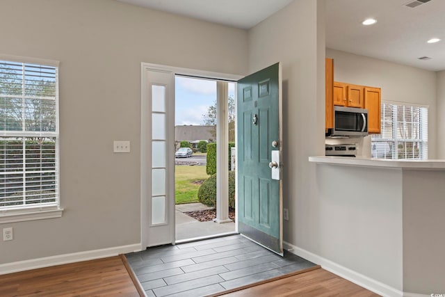 entryway with visible vents, baseboards, wood finished floors, and recessed lighting