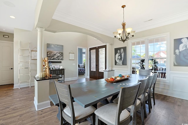 dining space with french doors, crown molding, an inviting chandelier, dark wood-type flooring, and decorative columns