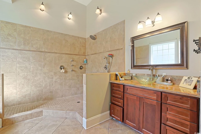 bathroom featuring vanity, tile patterned floors, and a tile shower