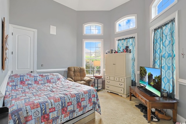 carpeted bedroom featuring a towering ceiling