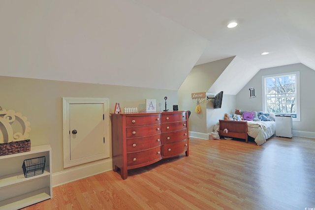 bedroom featuring light hardwood / wood-style floors and lofted ceiling