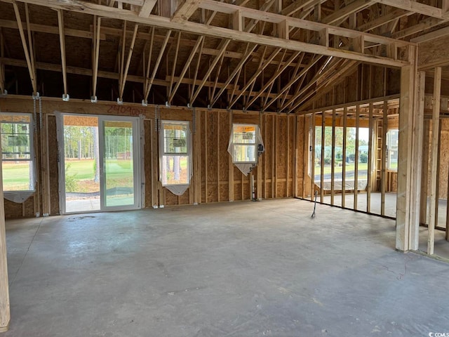 misc room featuring a wealth of natural light, concrete floors, and lofted ceiling