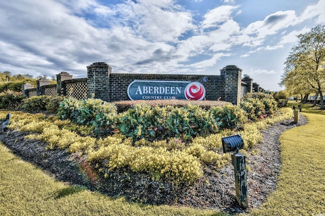 community / neighborhood sign featuring a lawn