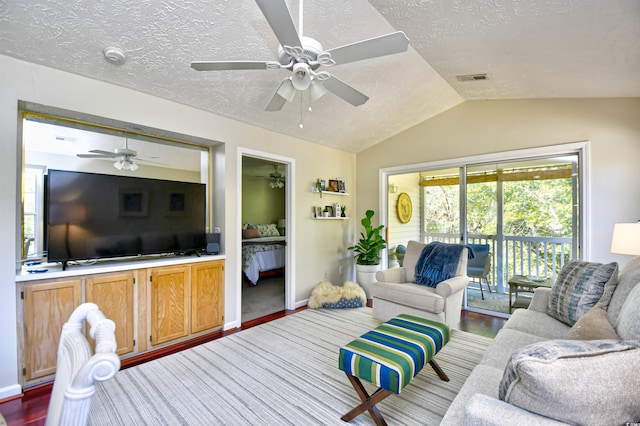 living room featuring a textured ceiling, vaulted ceiling, ceiling fan, and wood-type flooring